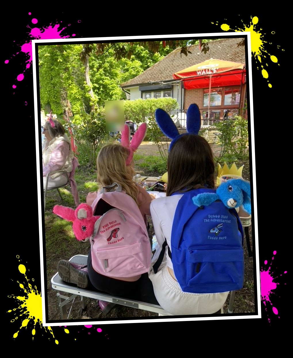 Two children with Pink Patsy and Bobby Blue Adventure Pack rucksacks at an outdoor craft table