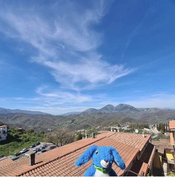 Bobby Blue on a rooftop looking out over the hills and mountains of the Aniene Valley at Rocca Santo Stefano, Italy