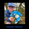 Child in a tree with the Bobby Blue Teddy Hare sitting on a branch beside him