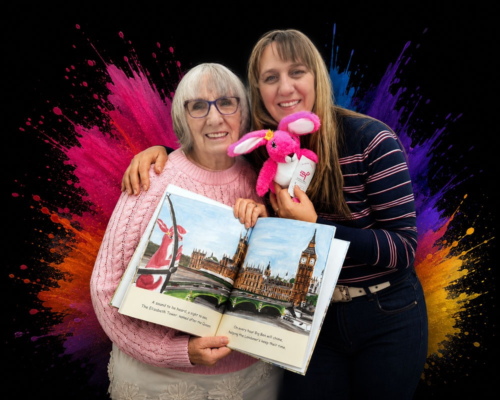 Margaret and Wendy, illustrator and author of Pink Patsy at Magmay Books, holding a Pink Patsy teddy and an open Pink Patsy book showing Big Ben, against a colourful paint splash