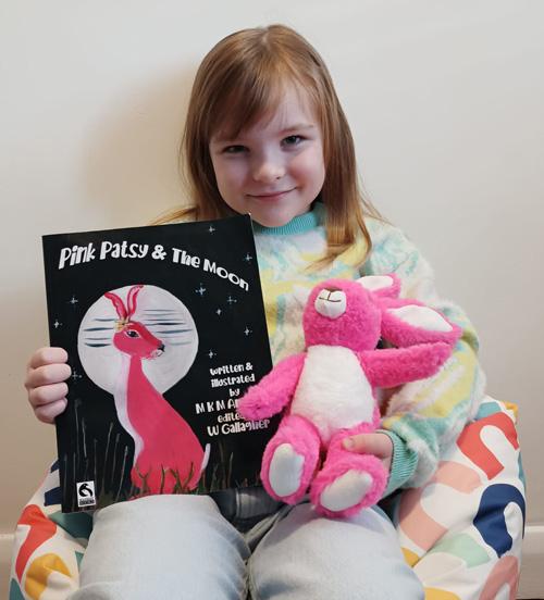 Young Pink Patsy fan holding Pink Patsy and the Moon and the Pink Patsy Teddy Hare