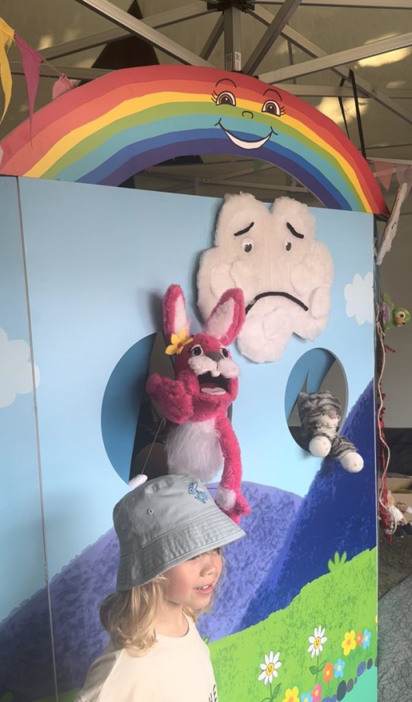 A child enjoying the Pink Patsy Puppet Show with Pink Patsy, the cloud and the cat puppets at East Finchley Festival