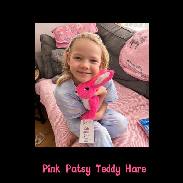 Smiling girl hugging her new Pink Patsy Teddy Hare at home