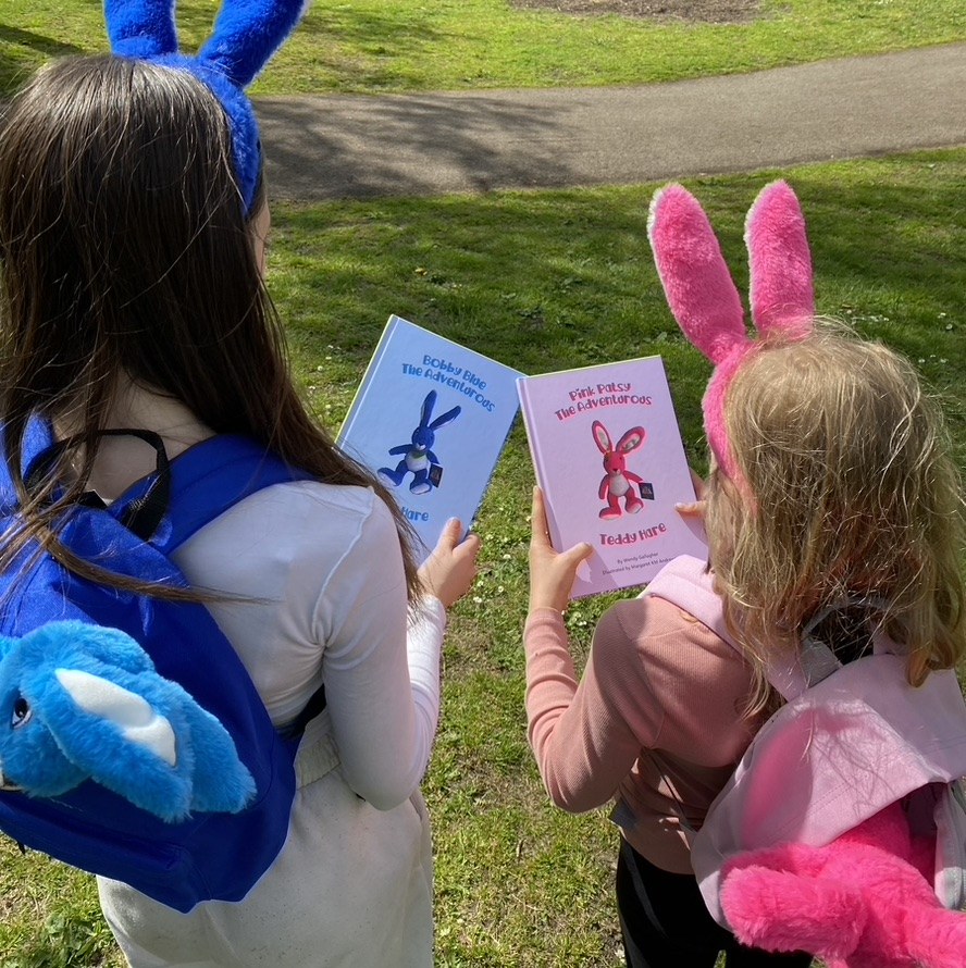 Children holding the books Bobby Blue The Adventurous Teddy Hare and Pink Patsy The Adventurous Teddy Hare