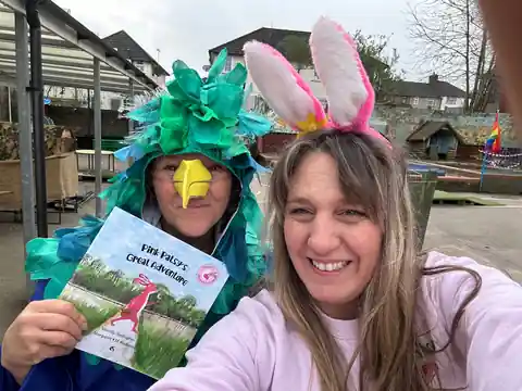 Wendy in pink bunny ears with a teacher dressed as a colourful bird holding Pink Patsy's Great Adventure