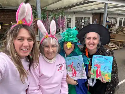 Wendy and Margaret in pink bunny ears with teachers in fancy dress holding Pink Patsy books